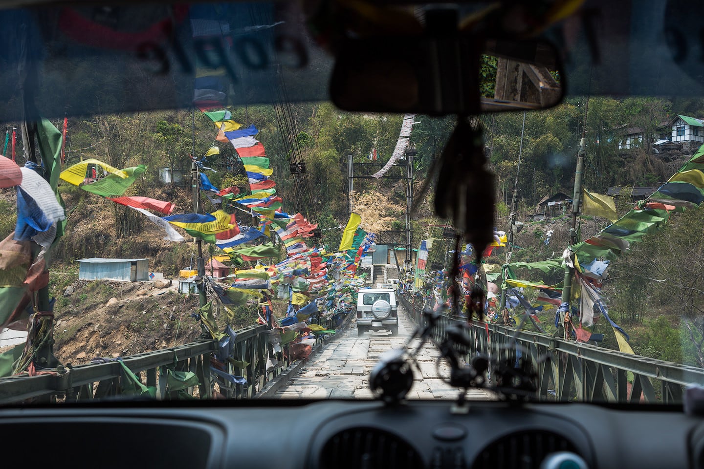 Crossing a bridge lined with prayer flags in North Sikkim.