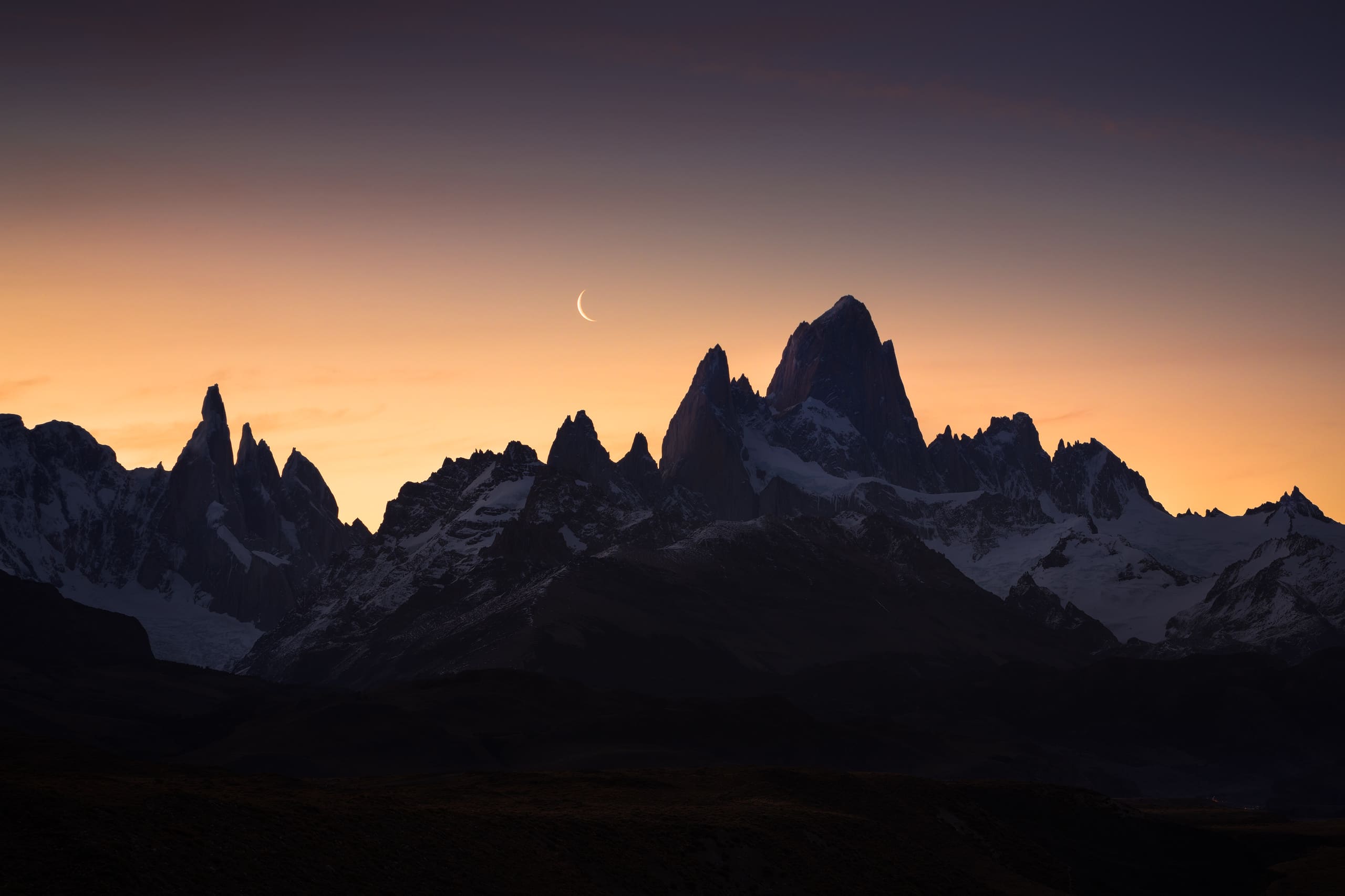 Crescent moon behind Cerro Torre and Fitz Roy at dusk