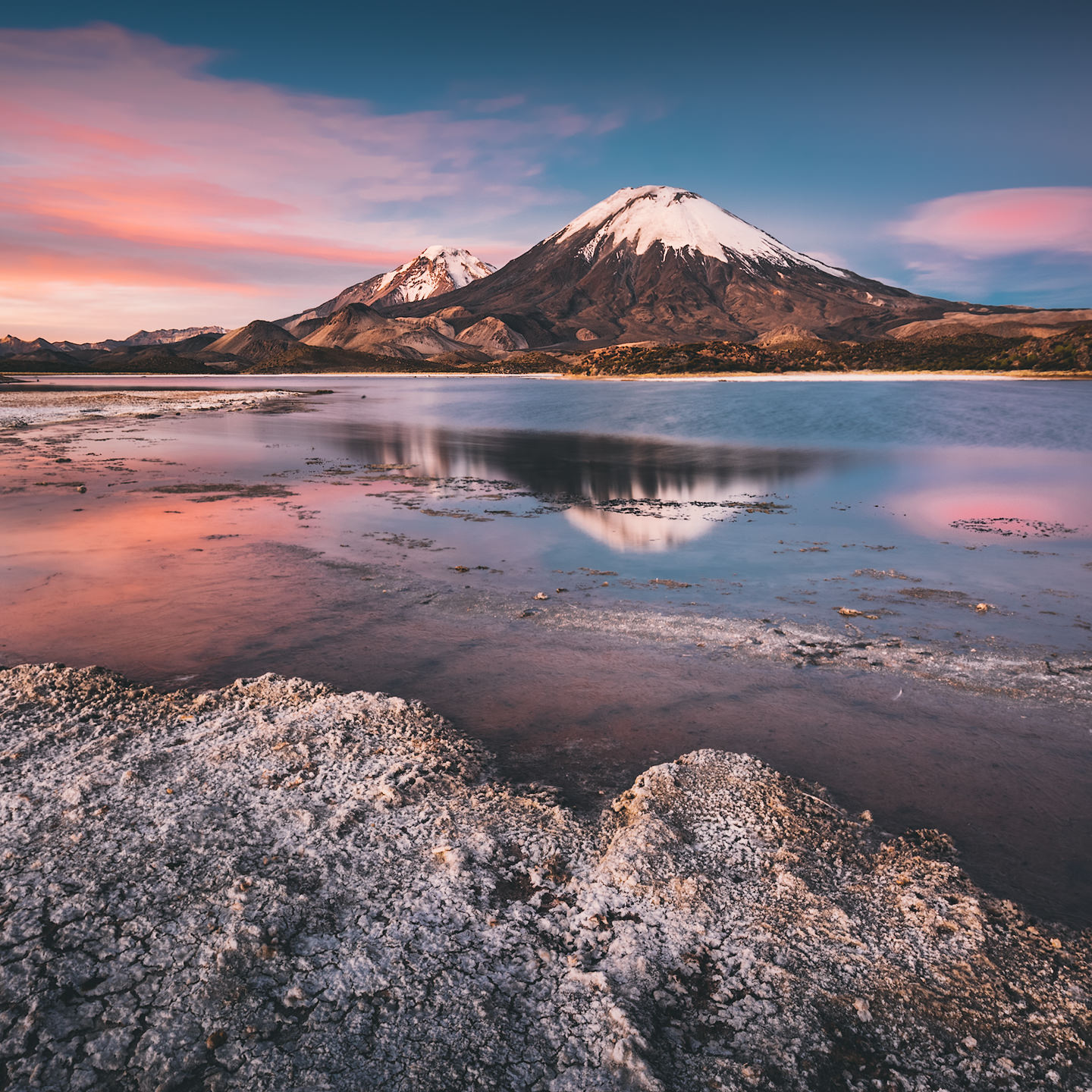 Volcanoes reflected in a lake at sunset.