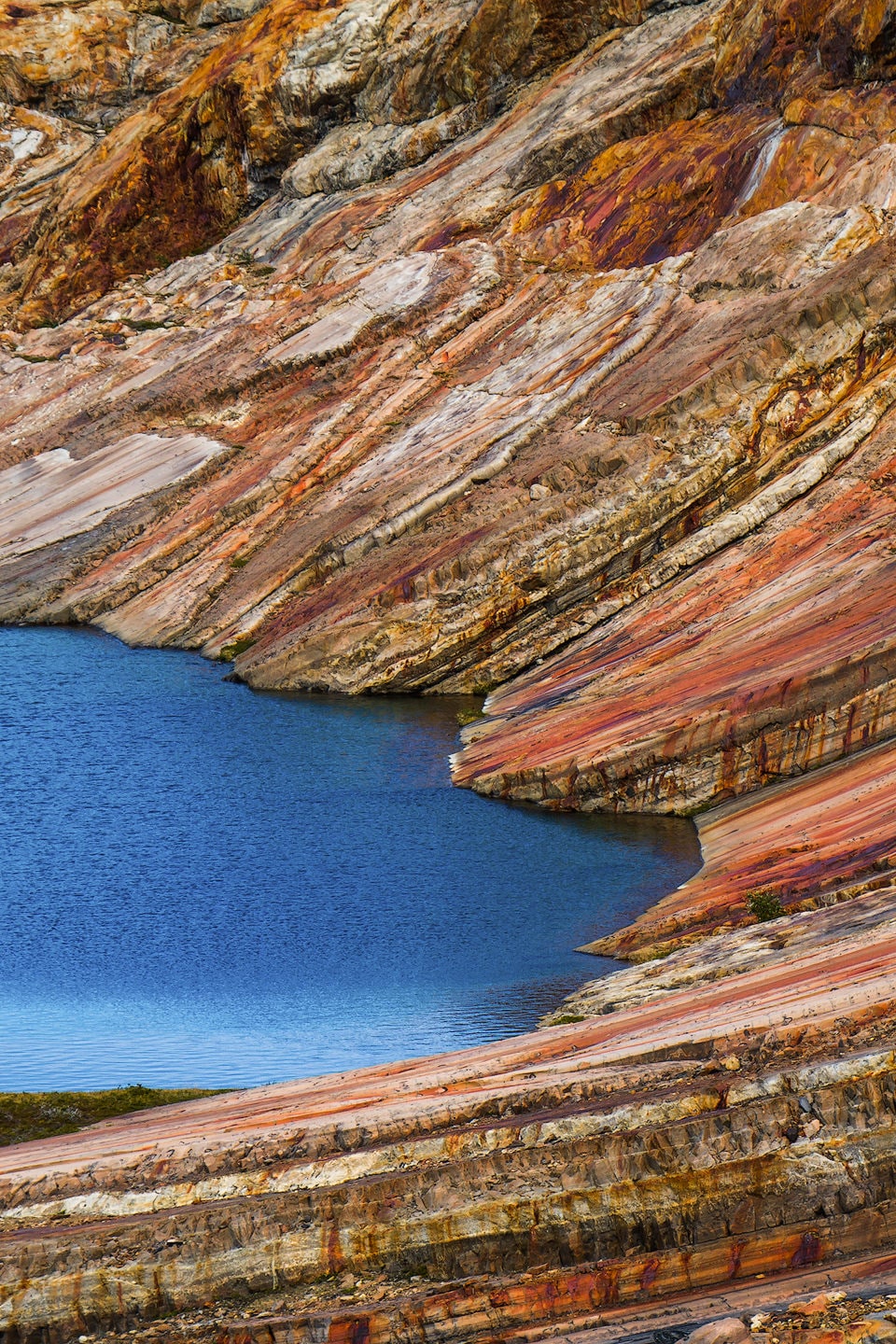 Colourful layers of rock and a lake