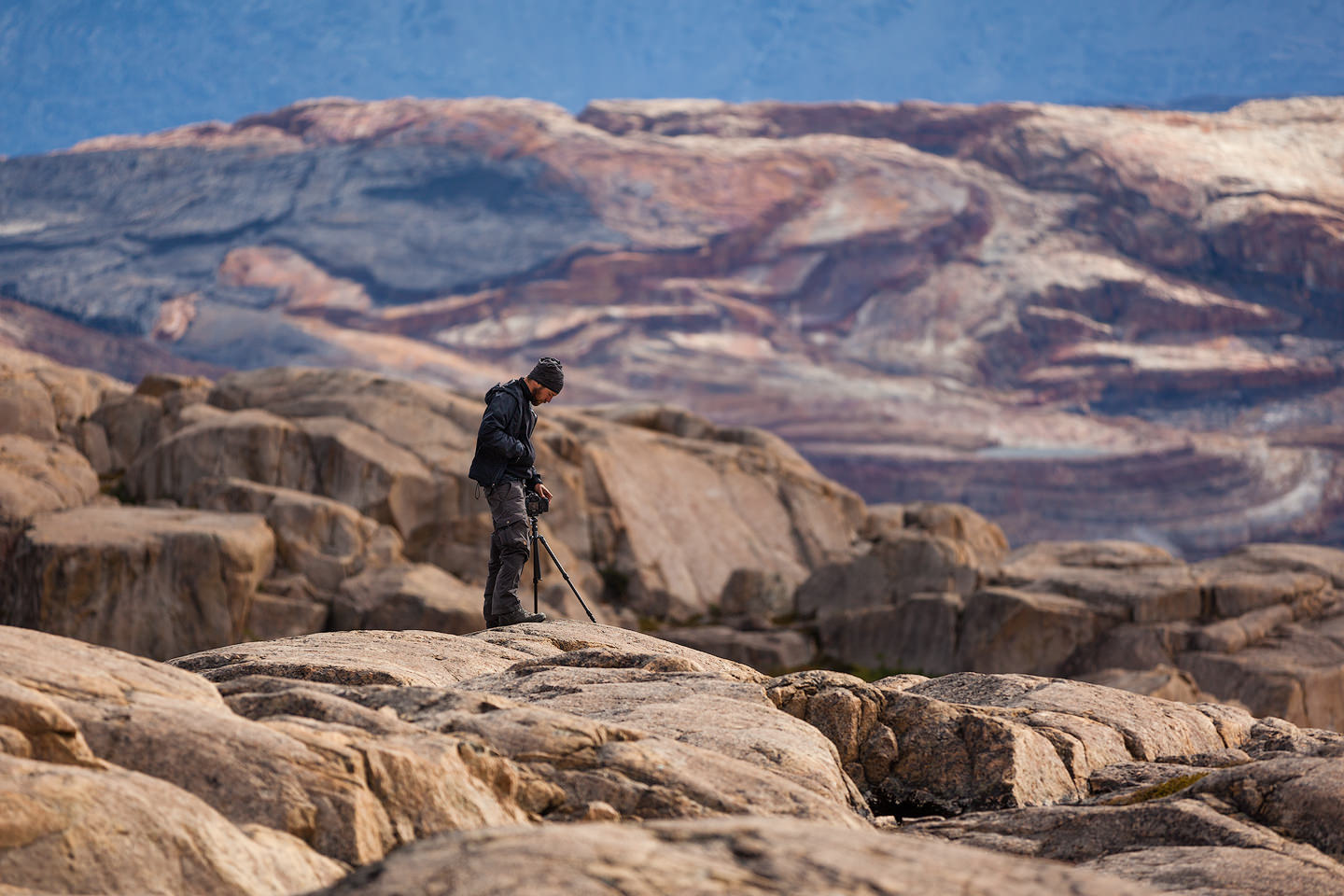 Joerg Bonner standing on a rock holding his camera and tripod.