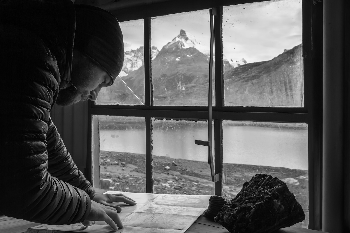 Joerg Bonner looking at a map inside a mountain shelter.